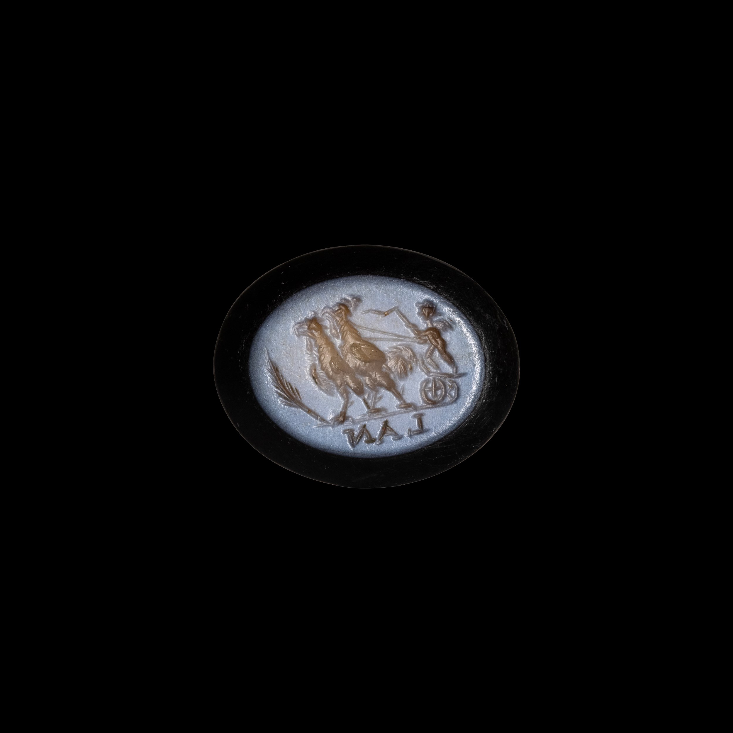 A Roman nicolo intaglio. Eros riding a chariot pulled by two roosters.